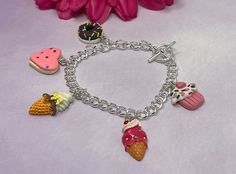 Sweet treats charm bracelet. Closure is a silver plated over brass toggle clasp. Chain is silver plated over steel curb chain. Bracelet includes five sweet treats charms, including: 1 chocolate donut, 1 sugar cookie, 2 ice cream cones, and 1 cupcake. Charms are acrylic and polymer clay.  Bracelet is handmade and new. Please realize that the bracelet may vary slightly from the one pictured based on the different lengths and / or clasps chosen. Please see sizing details in shop FAQ.  Is this a gif Sweet Handmade Silver Jewelry, Sweet Silver Handmade Jewelry, Sweet Nickel-free Dangle Jewelry, Playful Silver Charm Bracelet For Gift, Playful Silver Charm Bracelet As Gift, Playful Silver Charm Bracelet Perfect As A Gift, Cute Silver Dangle Charm Bracelet, Playful Handmade Silver Charm Bracelet, Playful Nickel-free Charm Bracelet For Gift