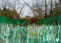 an abstract painting of grass and trees in the background