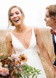 a bride and groom holding hands in a field