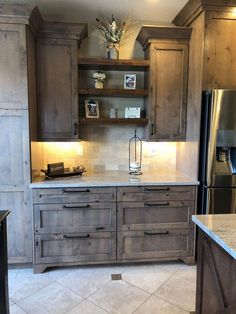 a kitchen with wooden cabinets and marble counter tops