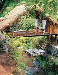 an outdoor area with a thatched roof and steps leading up to it