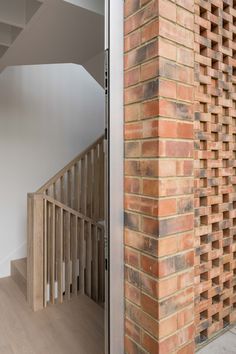 an open door to a brick building with wooden railings on the outside and inside