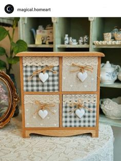 a small wooden dresser with hearts on the drawers and lace trimmings around it