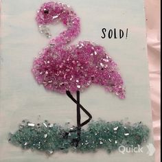 a pink flamingo is made out of glass beads and some green grass with the words sold on it