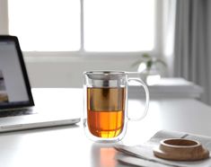 a cup of tea next to a laptop computer