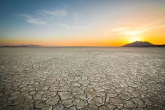 the sun is setting over an empty desert