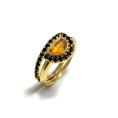 Made in solid 14k yellow gold this wedding ring set is unique in every sense of the word. Showcasing a majestic engagement ring with center half moon Citrine gem surrounded by a halo set with black spinel gems, and accompanied by a dainty black and gold half eternity ring inlaid with sparkling black Spinel gemstones. #jonjonjewel #ringset #engagementrings #weddingring #citrinring Boho Wedding Ring, Stacked Engagement Ring, Anniversary Ring Set, November Birthstone Ring, Turquoise Gold Ring, Deco Engagement Ring, Citrine Gemstone, Alternative Engagement Rings, Bridal Ring Set