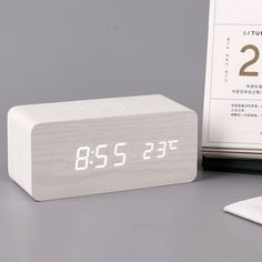 an alarm clock sitting on top of a desk next to a calendar