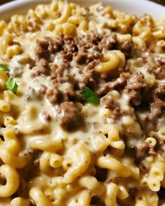 a white bowl filled with macaroni and cheese covered in ground beef