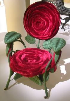 two large red flowers sitting on top of a white table