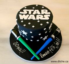 a star wars themed cake with two lightsabes on top and writing on the side