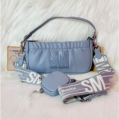 -Super Cute Light Blue Crossbody Bag That Can Be Worn 3 Different Ways. Bag Can Be Worn As A Crossbody Bag, Handbag, Or Wristlet. -Has "Sm Steve Madden" Logo On The Front Of Bag -Comes With Adjustable/Detachable Cotton Crossbody Strap And Shoulder Strap -Comes With Matching Pouch Which Can Be Taken Off If Needed -Has Rushing Design At The Top Of The Bag -Inside Has One Zippered Wall Pocket -Zipper Closure -New With Tags. No Damages Dimensions: W:8½" H:4¼" D:1½" Hand Carry Bag, Steve Madden Sunglasses, Blue Crossbody Bag, Earbud Case, Double Buckle Belt, Black Bucket Hat, Compact Bag, Bag Inside, Steve Madden Bags