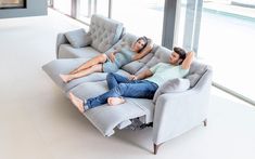 two people are lounging on a couch in the middle of an open floor plan