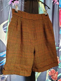 To-die-for dark academia staple. Rusty brown and burgundy plaid wool Bermuda shorts, 80s vintage, by Tanner Collection.  Hip pockets, cuffs, double pleats, and belt loops. Fully lined. Double hook-and-eye plus button and zipper closure. Medium-weight, soft wool. Made in USA. These are marked but are DEFINITELY NOT a size 12. Check your measurements, taken flat: waist 14.5", widest hip 22", length 21", 9" fly 8.5" inseam, 13" leg opening. Brown Workwear Shorts For Fall, Brown Shorts For Workwear In Fall, Brown Shorts For Workwear And Fall Season, Retro Short Bottoms For Fall, Plaid Short Bottoms For Fall, High Waist Brown Shorts For Fall, Brown Shorts With Pockets For Fall, Fitted Brown Shorts For Fall, High Waist Vintage Shorts For Workwear