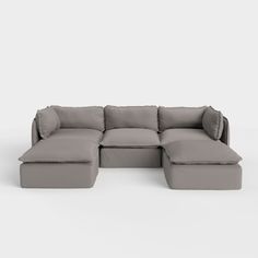 a gray sectional couch with pillows on it's back and the seat folded out