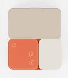 two orange and white buttons sitting next to each other on top of a white surface