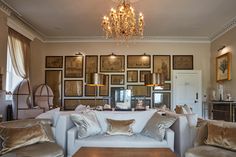 a living room filled with furniture and pictures on the wall