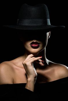 a woman wearing a black hat and red lipstick