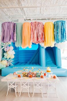 an inflatable tent is decorated with colorful streamers and tassels on the ceiling