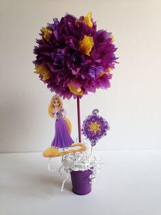 there is a purple and yellow flower in a glass vase with other decorations around it