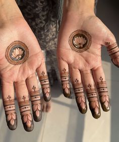 two hands with henna tattoos on them and one hand holding an object in the shape of a circle