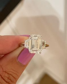 Michelle Demaree💍 on Instagram: "The Emerald Cut Ring with Trapezoids side stones: a classic three stone ring that exudes elegance. ✨  Pictured: 4 and 5 carat emerald cut diamonds with step cut trapezoids perfectly sourced to complement the center.🤍  Custom sourcing for clients around the US who are building their Rodeo Drive bespoke ring from the comfort of their home. 💍  www.missdiamondring.com  #emeraldcut #emeraldcutdiamond #emeraldcutengagementring #threestonering #trapezoids #3stonering #emeraldcutdiamond" Emerald Engagement Ring Side Stones, 3 Stone Emerald Cut Ring, 5 Carat Emerald Cut Engagement Ring, Emerald Cut Engagement Ring With Side Stones, Emerald Cut Engagement Ring With Trapezoids, Emerald Cut With Trapezoids, Emerald Cut 3 Stone Engagement Ring, Emerald Cut Engagement Ring 3 Stone