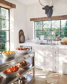 a kitchen filled with lots of food on top of a counter next to a window