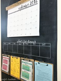 a chalk board with calendars hanging on it