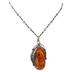 A vintage hand crafted pendant with a silver link necklace. The pendant is made from a drop shaped amber cabochon and it is in an oval silver frame decorated with silver leaves. The necklace and the pendant are marked KS, there are also other marks difficult to read. There is no clear mark for the silver content, but the item was tested by an expert and it tested positive for the 925 silver content. The pendant and necklace are in very good vintage condition. The necklace was manufactured in Pol Artisan Amber Cabochon Necklace, Adjustable Brown Artistic Necklace, Amber Cabochon Necklace In Sterling Silver, Luxury Carved Amber Necklaces, Vintage Red Cabochon Necklace, Silver Link Necklace, Amber Jewelry, Link Necklace, Silver Frame