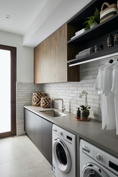 a washer and dryer in a room with open shelves on either side of the door