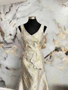 a dress on display in front of a marble wall