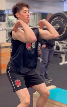 a man is lifting a barbell in the gym