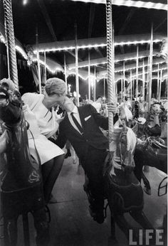 a man kissing a woman on a merry go round