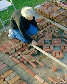 a man laying bricks on the ground