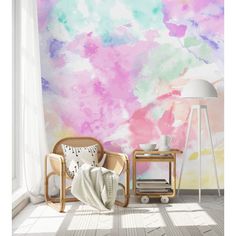 a chair and lamp in front of a colorful wall mural