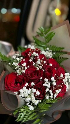 a bouquet of red roses and baby's breath