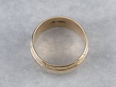 This wide vintage band is crafted entirely of 14k yellow gold. The center of this ring is slightly domed, giving it the ability to catch the light, and is accented by the masculine carvings on the edge. Metal: 14K Yellow Gold Width of Band: 7.8 mm Height off Finger: 1.5 mm Ring Size: 6 Marks: "A14K" Stamped on the inside band Yellow Gold Thick Band Ring, Heirloom Dome Ring With Wide Band For Anniversary, Heirloom Wide Band Yellow Gold Ring, Heirloom Ring With Thick Decorative Band, Heirloom Wide Band Engraved Ring For Anniversary, Heirloom Engraved Wide Band Ring For Anniversary, Heirloom Engraved Ring With Decorative Wide Band, Heirloom Rings With Decorative Wide Band, Heirloom Yellow Gold Wide Band Ring