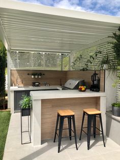 an outdoor kitchen and dining area with sliding glass doors that open up to the backyard