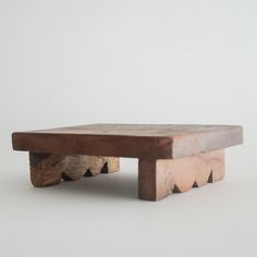 a small wooden bench sitting on top of a white floor