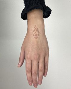 a woman's hand with a small tattoo on it