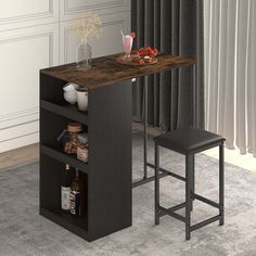 a kitchen table with two stools in front of it and a shelf on the other side