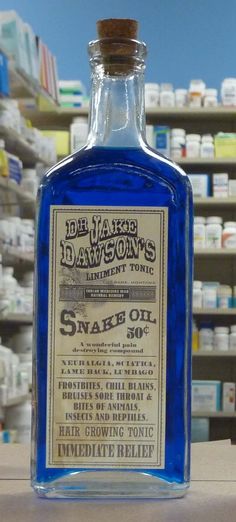 a bottle of blue liquid sitting on top of a table next to shelves filled with bottles