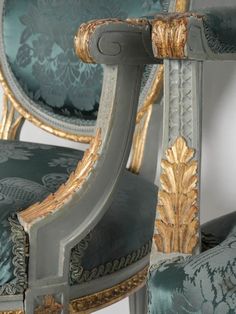 an ornately decorated chair with gold trimmings and blue upholstered fabric