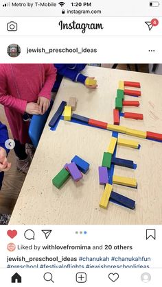 two children are playing with wooden blocks on the table and one child is pointing at them