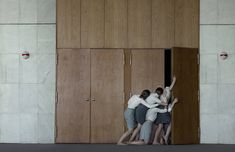 three people hugging each other in front of wooden doors