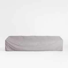 an empty gray couch sitting on top of a white floor