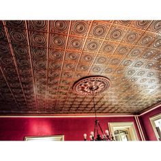 a chandelier hanging from the ceiling in a room with red walls and ceilings