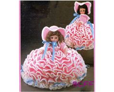 two crocheted dolls in pink dresses and bonnets with blue bows on their heads