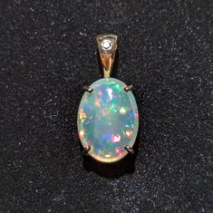 Rainbow Ethiopian Opal Pendant set in 14k yellow gold with diamond in the bail. Rabbit Pendant, Tacoma Wa, Yellow Gold Pendants, Opal Pendants, White Sapphire, Oval Cabochon, Pendant Set, Ethiopian Opal, Fire Opal