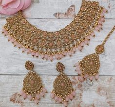 Antique gold flexible Indian Asian necklace jewellery set with tikka headpiece & earrings. Perfect bridal set for a sweetheart neckline.  Gold base filled with antique tone stones & baby pink beads.  Earring drop: 7 cm approx Tikka Headpiece, Pink Antique, Gold Bridal Necklace, Engagement Necklaces, Necklace Set Indian, Bridal Necklace Set, Earring Drop, Indian Necklace, Gold Long Necklace